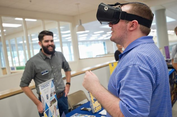 A prospective student wearing VR glasses at a college fair