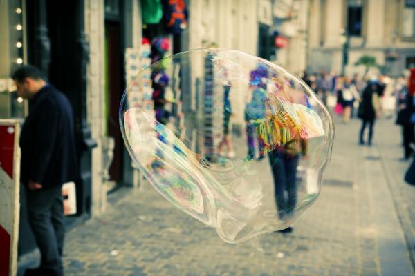 bubble floating in the city with people walking in the background