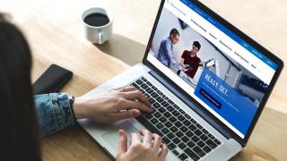 A woman views the Widener homepage on a laptop