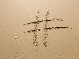 a hashtag drawn in sand