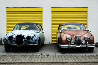 two cars, side-by-side, one decrepit and one refurbished