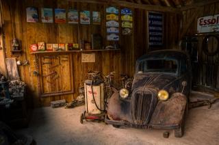 a dusty old car sitting in a garage