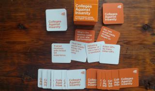 Colleges Against Insanity game cards spread out on a table