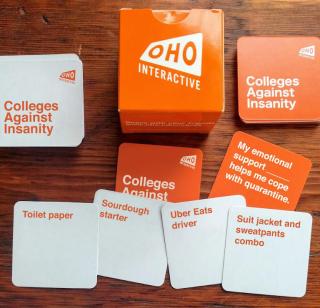 Colleges Against Insanity cards, spread out on a wood table