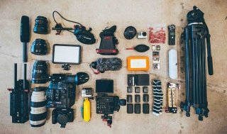 An expansive collection of photography equipment, lined up on the floor very neatly