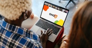 Two women engage with an OHO U webinar on a laptop