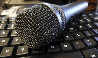 A microphone laying on a keyboard