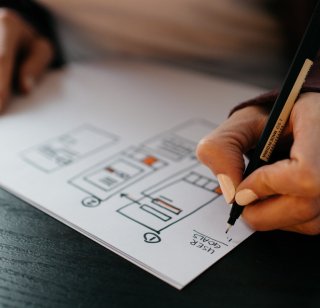 A woman draws wireframes on a piece of paper