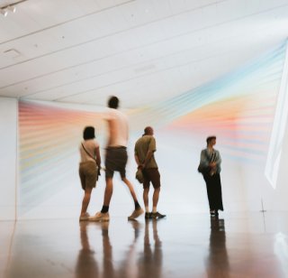 Four people stand in an art exhibit