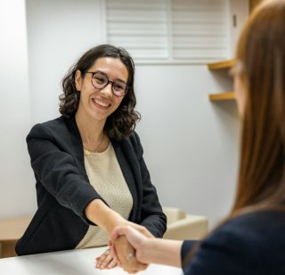 Two women shake hands following a job interview