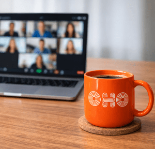 OHO coffee mug in front of an open laptop